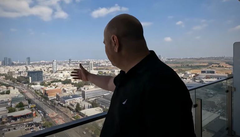 ניב רום, מנכ"ל כנען, משקיף לנוף מהמרפסת של המשרד החדש בקומה ה-26